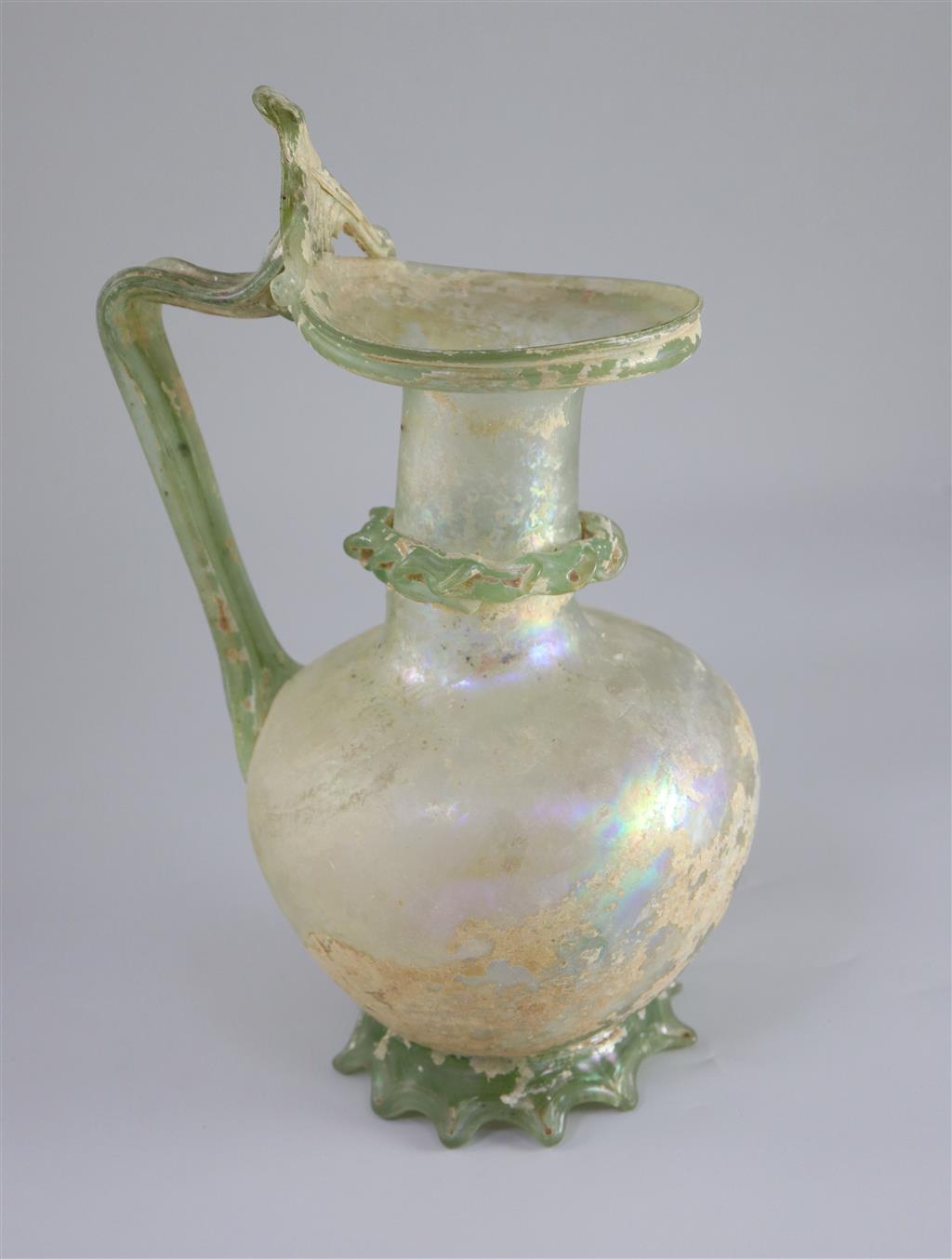 A good Roman olive green glass ewer or pitcher, Eastern Mediterranean, 3rd/4th century AD, 32cm high